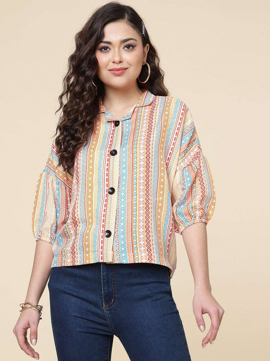 The model in the image is wearing Multi Colour Printed Casual Wear Rayon Shirt For Women from Alice Milan. Crafted with the finest materials and impeccable attention to detail, the Western Wear Top looks premium, trendy, luxurious and offers unparalleled comfort. It’s a perfect clothing option for loungewear, resort wear, party wear or for an airport look. The woman in the image looks happy, and confident with her style statement putting a happy smile on her face.