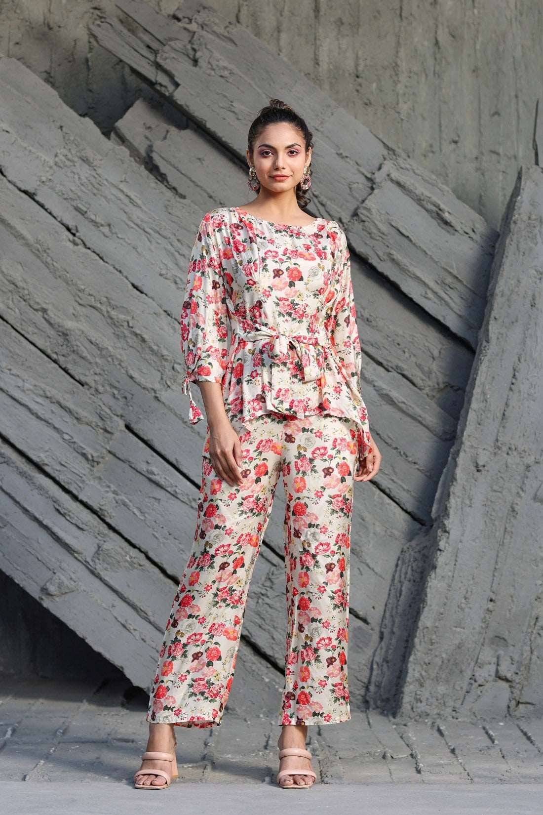 The model in the image is wearing Floral Printed Cotton Coordinate Sets Womens from Alice Milan. Crafted with the finest materials and impeccable attention to detail, the Co-ord Set looks premium, trendy, luxurious and offers unparalleled comfort. It’s a perfect clothing option for loungewear, resort wear, party wear or for an airport look. The woman in the image looks happy, and confident with her style statement putting a happy smile on her face.