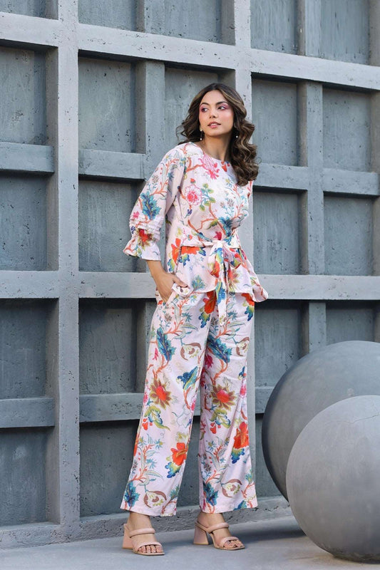 The model in the image is wearing Floral Printed Cotton White Co ord Set from Alice Milan. Crafted with the finest materials and impeccable attention to detail, the Co-ord Set looks premium, trendy, luxurious and offers unparalleled comfort. It’s a perfect clothing option for loungewear, resort wear, party wear or for an airport look. The woman in the image looks happy, and confident with her style statement putting a happy smile on her face.