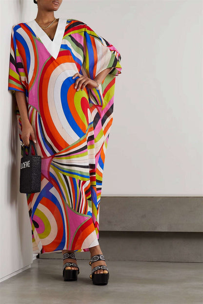 The model in the image is wearing Printed Colorful Soft Cotton Blend Kaftan from Alice Milan. Crafted with the finest materials and impeccable attention to detail, the Kaftan / Dress looks premium, trendy, luxurious and offers unparalleled comfort. It’s a perfect clothing option for loungewear, resort wear, party wear or for an airport look. The woman in the image looks happy, and confident with her style statement putting a happy smile on her face.