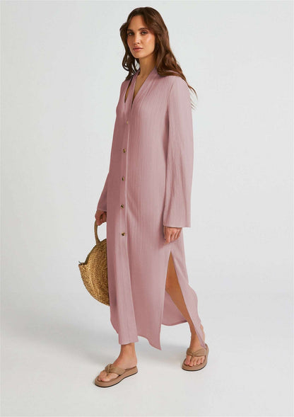The model in the image is wearing Baby Pink Premium Oyster Crush Women Dress from Alice Milan. Crafted with the finest materials and impeccable attention to detail, the Dress looks premium, trendy, luxurious and offers unparalleled comfort. It’s a perfect clothing option for loungewear, resort wear, party wear or for an airport look. The woman in the image looks happy, and confident with her style statement putting a happy smile on her face.