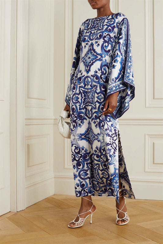 The model in the image is wearing Blue Colour Printed Organza Silk Party Wear Kaftan from Alice Milan. Crafted with the finest materials and impeccable attention to detail, the Kaftan / Dress looks premium, trendy, luxurious and offers unparalleled comfort. It’s a perfect clothing option for loungewear, resort wear, party wear or for an airport look. The woman in the image looks happy, and confident with her style statement putting a happy smile on her face.