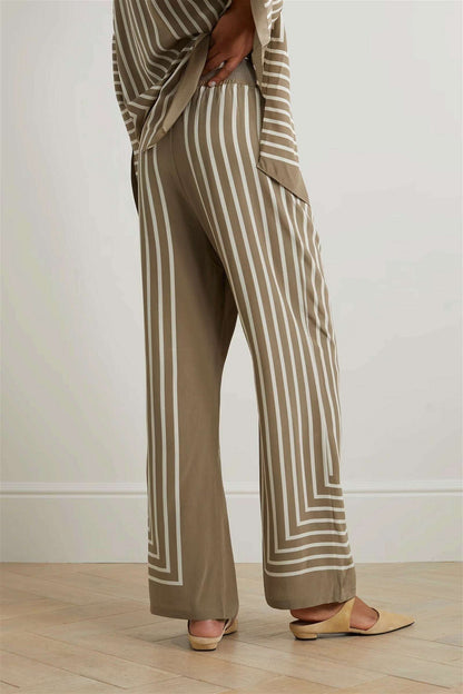 The model in the image is wearing Luxe Striped - Modest Co ord Set from Alice Milan. Crafted with the finest materials and impeccable attention to detail, the Co-ord Set looks premium, trendy, luxurious and offers unparalleled comfort. It’s a perfect clothing option for loungewear, resort wear, party wear or for an airport look. The woman in the image looks happy, and confident with her style statement putting a happy smile on her face.