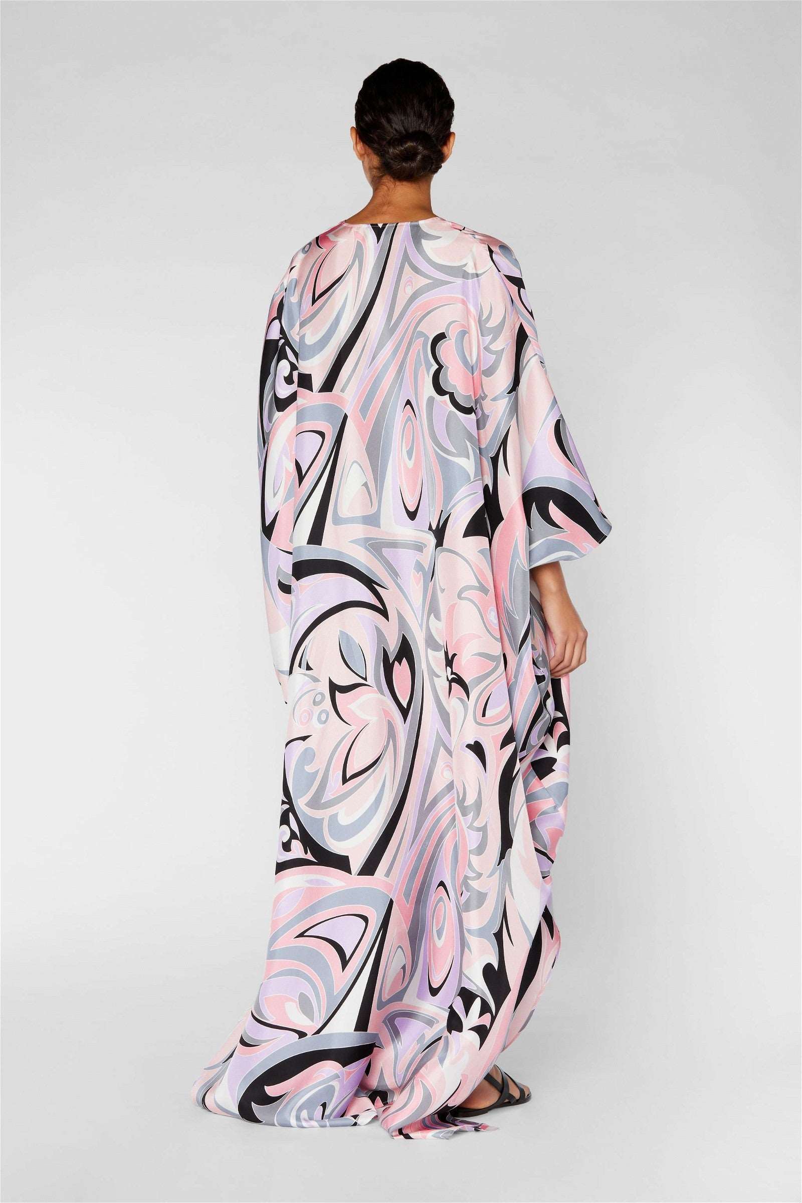 The model in the image is wearing Pink Colour Printed Satin Silk Party Wear Kaftan from Alice Milan. Crafted with the finest materials and impeccable attention to detail, the Kaftan / Dress looks premium, trendy, luxurious and offers unparalleled comfort. It’s a perfect clothing option for loungewear, resort wear, party wear or for an airport look. The woman in the image looks happy, and confident with her style statement putting a happy smile on her face.