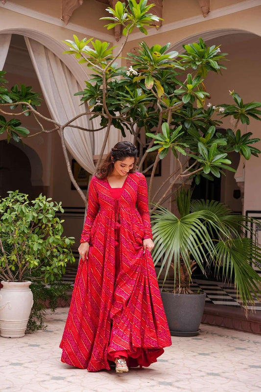 The model in the image is wearing Beautiful Printed Shrug Style Indo Western Gown For Women from Alice Milan. Crafted with the finest materials and impeccable attention to detail, the  looks premium, trendy, luxurious and offers unparalleled comfort. It’s a perfect clothing option for loungewear, resort wear, party wear or for an airport look. The woman in the image looks happy, and confident with her style statement putting a happy smile on her face.