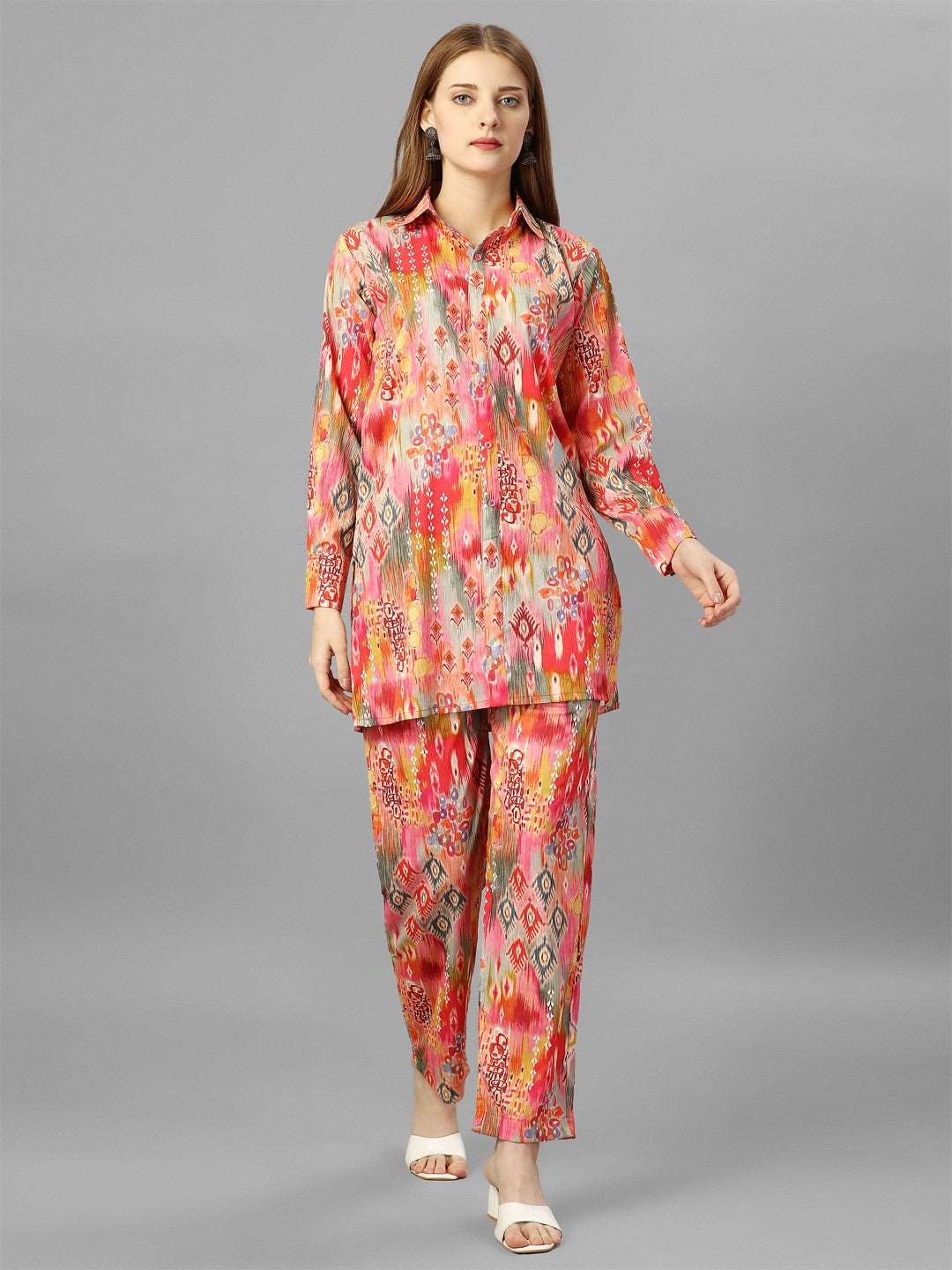 The model in the image is wearing Orange Floral Cotton Co-Ord Set from Alice Milan. Crafted with the finest materials and impeccable attention to detail, the  looks premium, trendy, luxurious and offers unparalleled comfort. It’s a perfect clothing option for loungewear, resort wear, party wear or for an airport look. The woman in the image looks happy, and confident with her style statement putting a happy smile on her face.