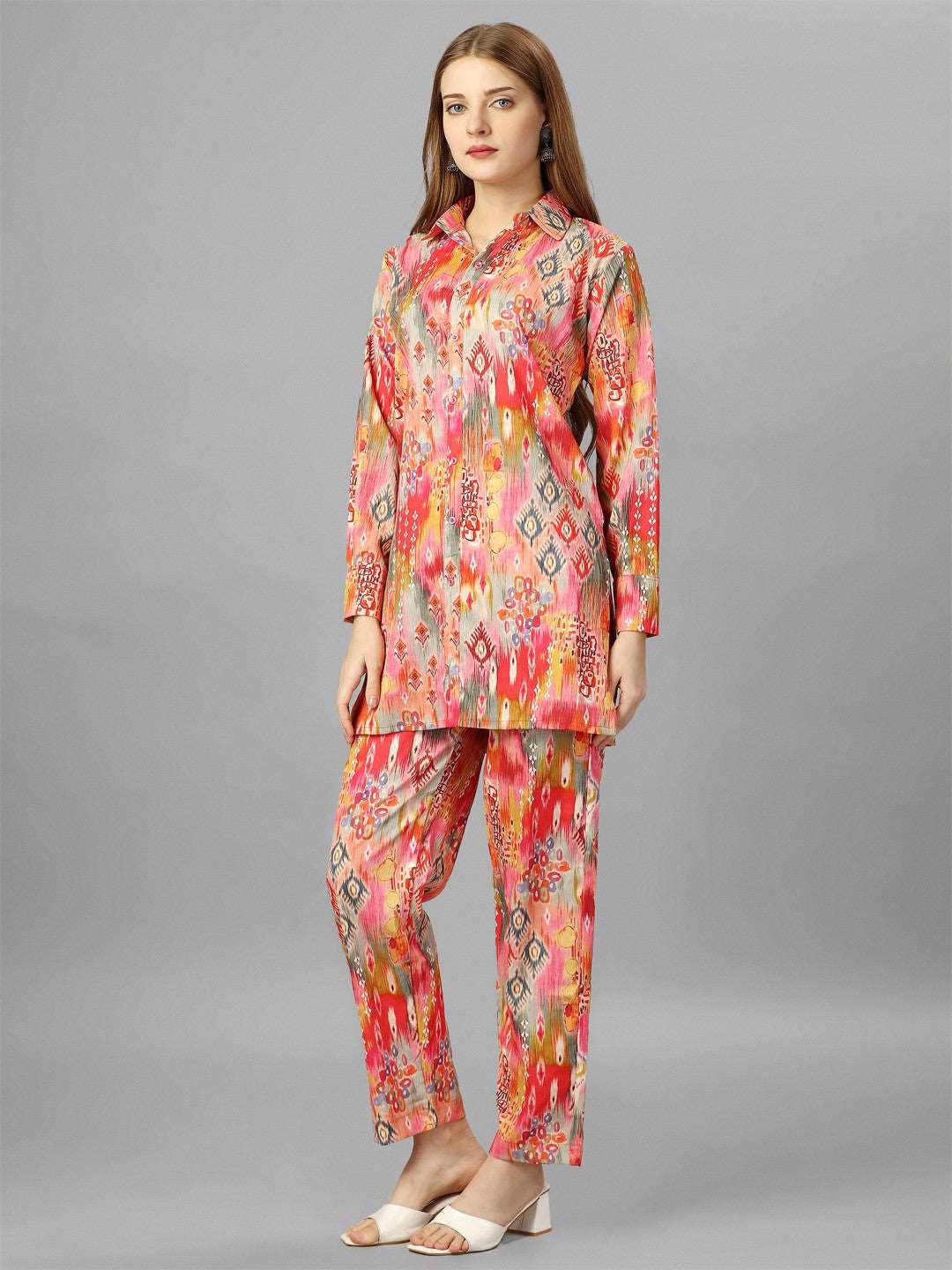 The model in the image is wearing Orange Floral Cotton Co-Ord Set from Alice Milan. Crafted with the finest materials and impeccable attention to detail, the  looks premium, trendy, luxurious and offers unparalleled comfort. It’s a perfect clothing option for loungewear, resort wear, party wear or for an airport look. The woman in the image looks happy, and confident with her style statement putting a happy smile on her face.