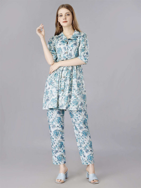 The model in the image is wearing Printed Blue 2-Piece Shirt & Trousers Set from Alice Milan. Crafted with the finest materials and impeccable attention to detail, the  looks premium, trendy, luxurious and offers unparalleled comfort. It’s a perfect clothing option for loungewear, resort wear, party wear or for an airport look. The woman in the image looks happy, and confident with her style statement putting a happy smile on her face.