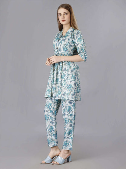 The model in the image is wearing Printed Blue 2-Piece Shirt & Trousers Set from Alice Milan. Crafted with the finest materials and impeccable attention to detail, the  looks premium, trendy, luxurious and offers unparalleled comfort. It’s a perfect clothing option for loungewear, resort wear, party wear or for an airport look. The woman in the image looks happy, and confident with her style statement putting a happy smile on her face.