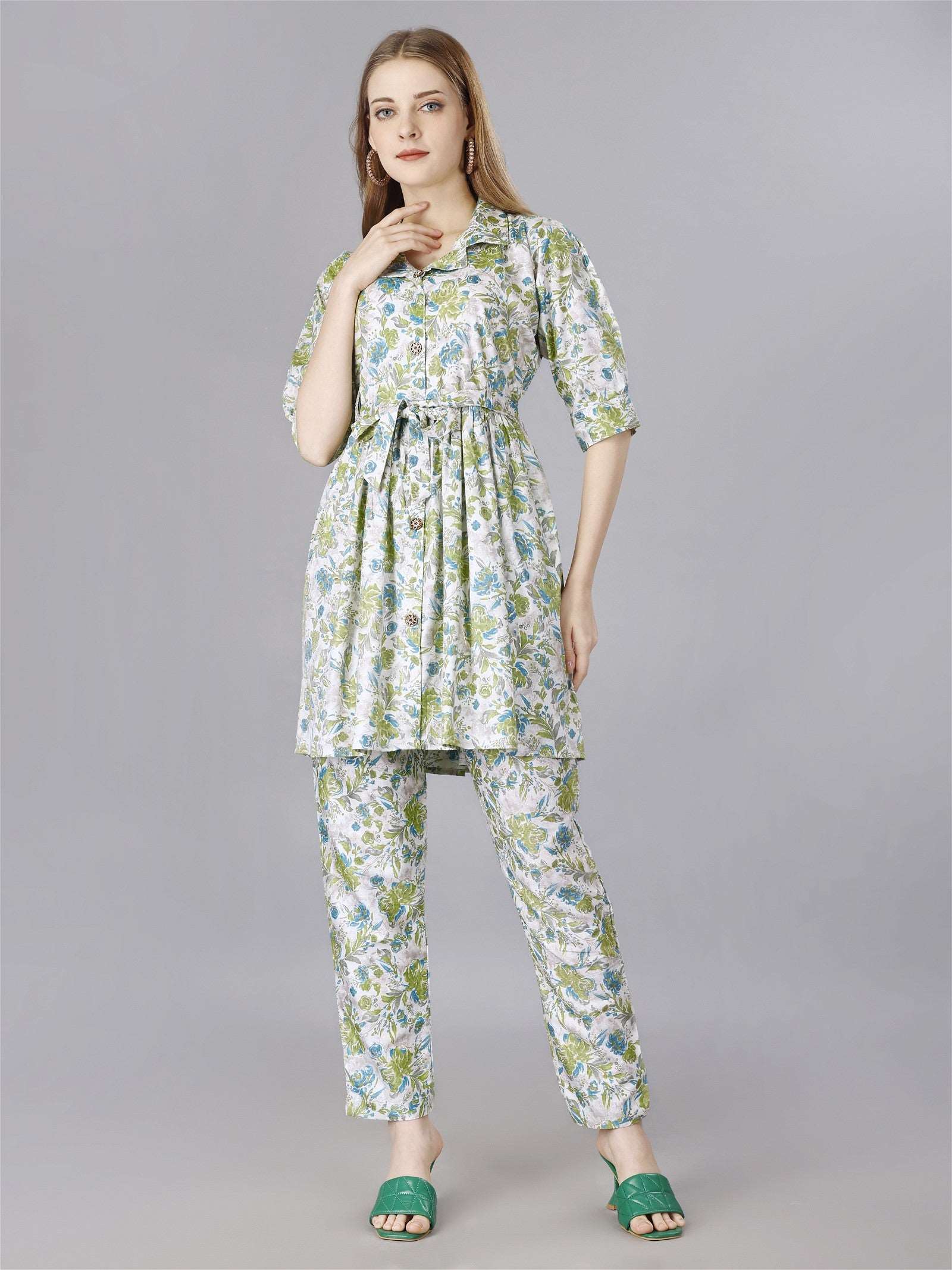 The model in the image is wearing Printed Green Cotton 2-Piece Shirt & Trousers Set from Alice Milan. Crafted with the finest materials and impeccable attention to detail, the  looks premium, trendy, luxurious and offers unparalleled comfort. It’s a perfect clothing option for loungewear, resort wear, party wear or for an airport look. The woman in the image looks happy, and confident with her style statement putting a happy smile on her face.