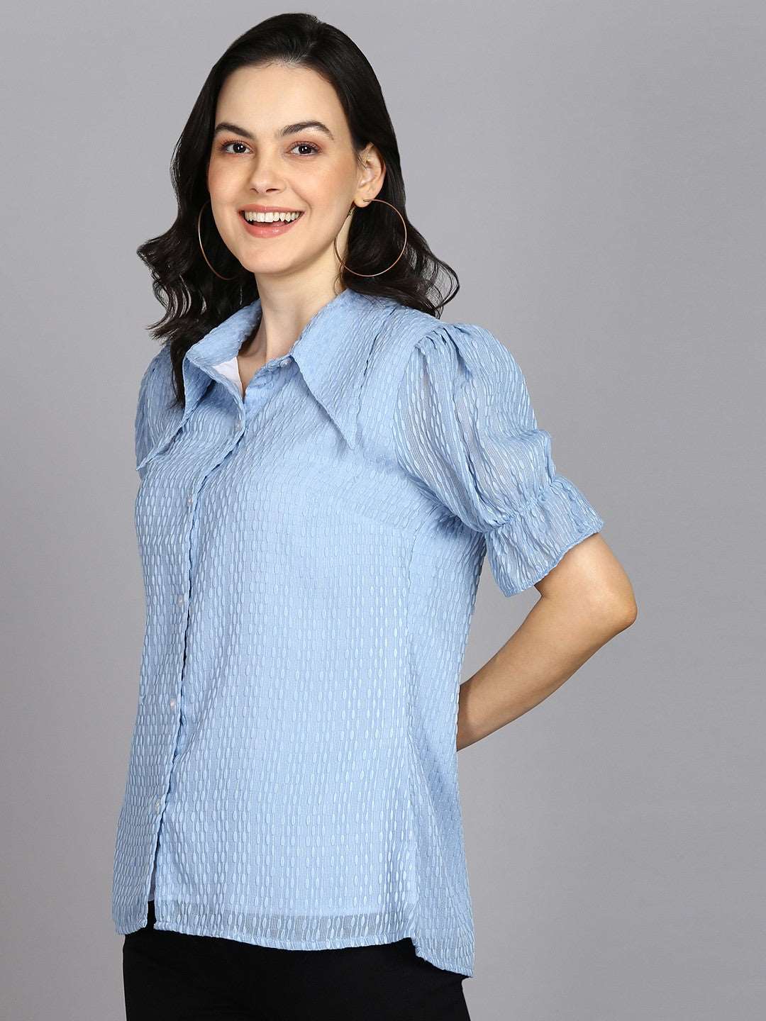 The model in the image is wearing Casual Regular Sleeves Self Design Women Sky Blue Top from Alice Milan. Crafted with the finest materials and impeccable attention to detail, the Western Wear Top looks premium, trendy, luxurious and offers unparalleled comfort. It’s a perfect clothing option for loungewear, resort wear, party wear or for an airport look. The woman in the image looks happy, and confident with her style statement putting a happy smile on her face.