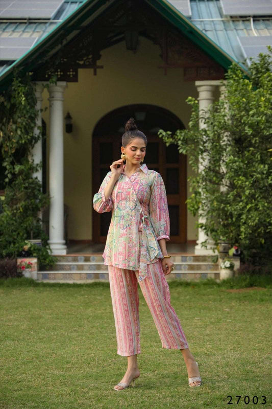 The model in the image is wearing Pink Floral Loungewear Co ord Set Women from Alice Milan. Crafted with the finest materials and impeccable attention to detail, the  looks premium, trendy, luxurious and offers unparalleled comfort. It’s a perfect clothing option for loungewear, resort wear, party wear or for an airport look. The woman in the image looks happy, and confident with her style statement putting a happy smile on her face.