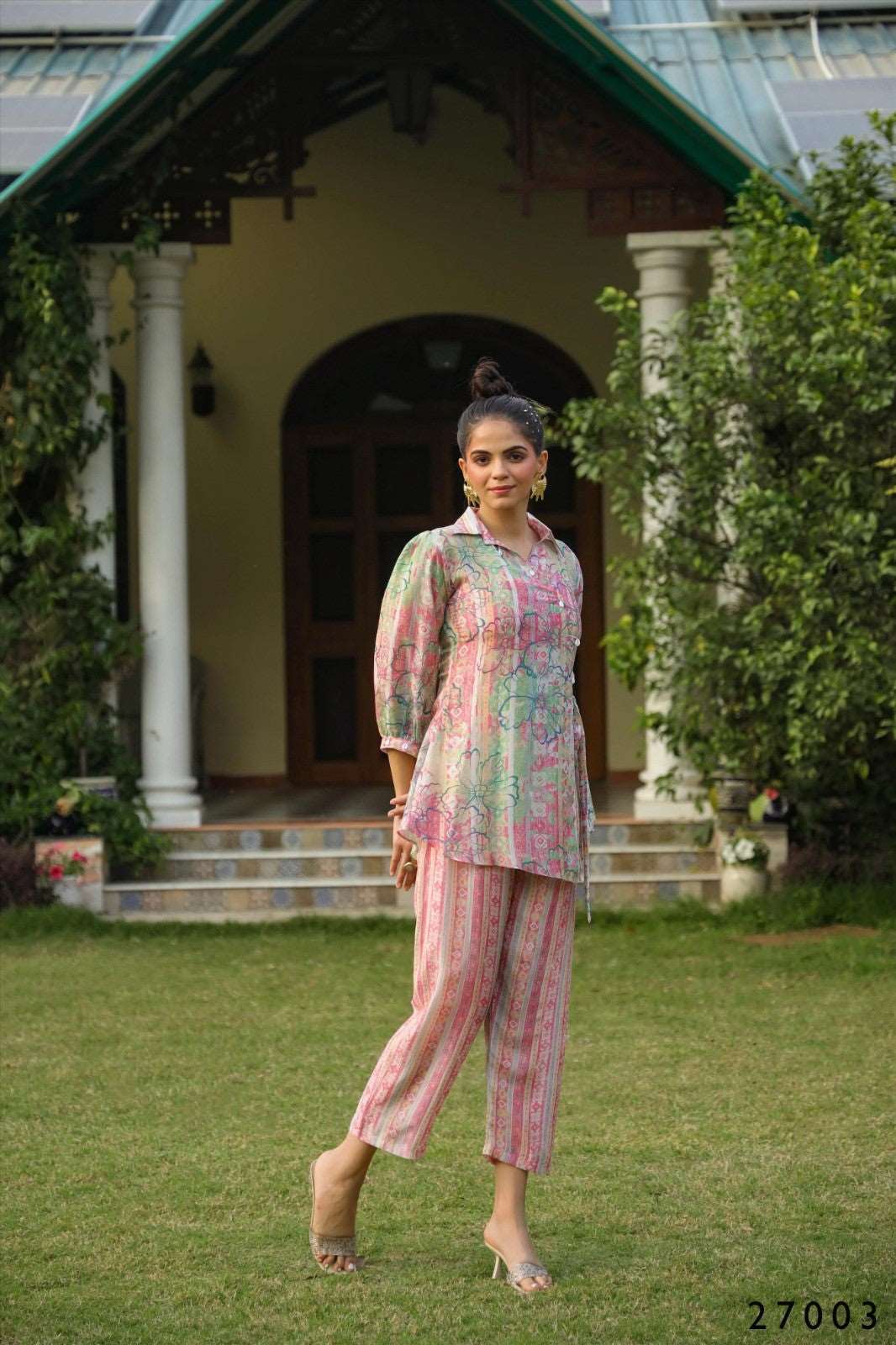 The model in the image is wearing Pink Floral Loungewear Co ord Set Women from Alice Milan. Crafted with the finest materials and impeccable attention to detail, the  looks premium, trendy, luxurious and offers unparalleled comfort. It’s a perfect clothing option for loungewear, resort wear, party wear or for an airport look. The woman in the image looks happy, and confident with her style statement putting a happy smile on her face.