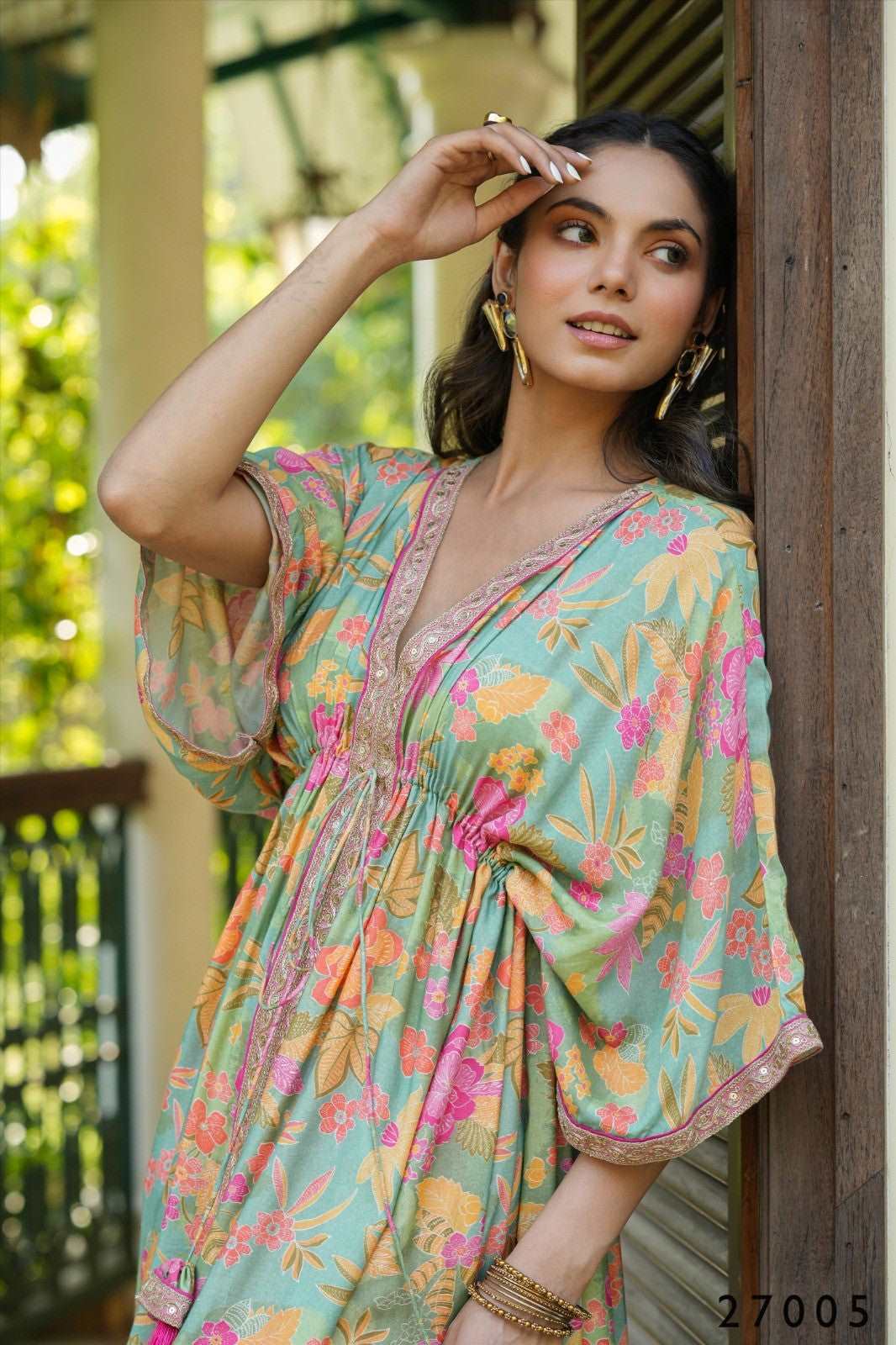 The model in the image is wearing Floral Print Kaftan Tunic with Palazzo from Alice Milan. Crafted with the finest materials and impeccable attention to detail, the  looks premium, trendy, luxurious and offers unparalleled comfort. It’s a perfect clothing option for loungewear, resort wear, party wear or for an airport look. The woman in the image looks happy, and confident with her style statement putting a happy smile on her face.