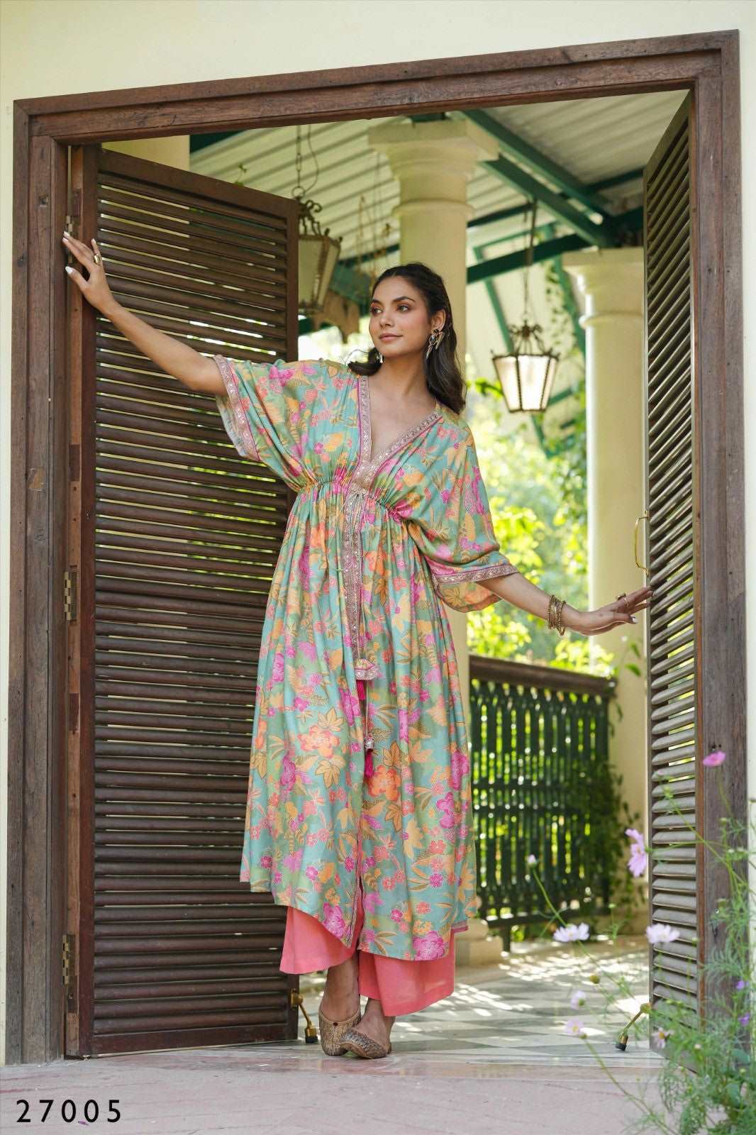 The model in the image is wearing Floral Print Kaftan Tunic with Palazzo from Alice Milan. Crafted with the finest materials and impeccable attention to detail, the  looks premium, trendy, luxurious and offers unparalleled comfort. It’s a perfect clothing option for loungewear, resort wear, party wear or for an airport look. The woman in the image looks happy, and confident with her style statement putting a happy smile on her face.
