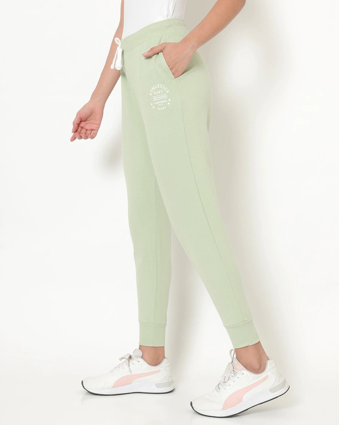 The model in the image is wearing Amazing Joggers For Womens Pure Cotton from Alice Milan. Crafted with the finest materials and impeccable attention to detail, the Joggers looks premium, trendy, luxurious and offers unparalleled comfort. It’s a perfect clothing option for loungewear, resort wear, party wear or for an airport look. The woman in the image looks happy, and confident with her style statement putting a happy smile on her face.