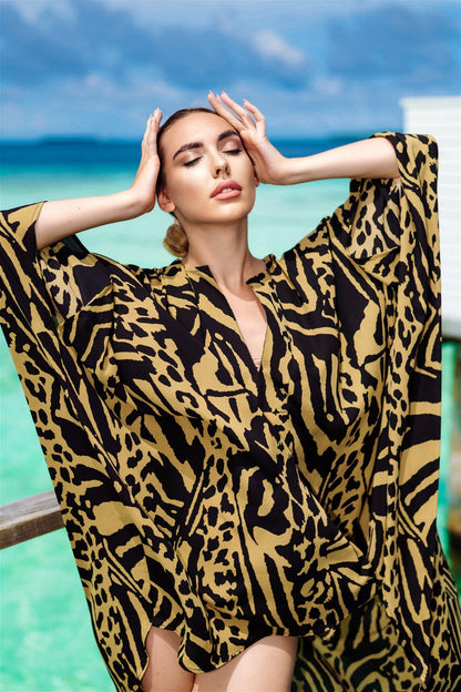 The model in the image is wearing Printed Yellow Kaftan In Silk Fabric from Alice Milan. Crafted with the finest materials and impeccable attention to detail, the Kaftan / Dress looks premium, trendy, luxurious and offers unparalleled comfort. It’s a perfect clothing option for loungewear, resort wear, party wear or for an airport look. The woman in the image looks happy, and confident with her style statement putting a happy smile on her face.