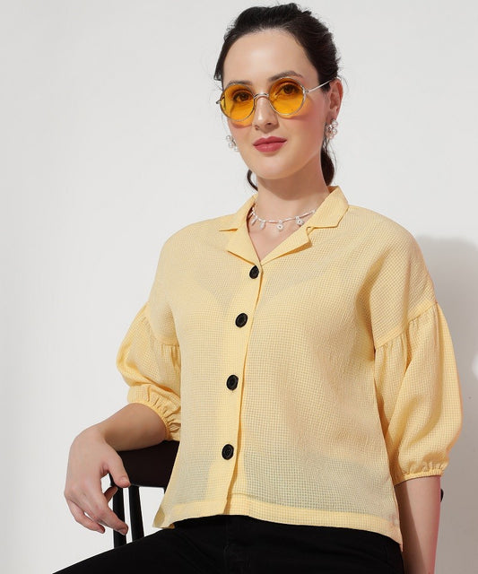 The model in the image is wearing Peach Yellow Georgette Casual Women's Shirt from Alice Milan. Crafted with the finest materials and impeccable attention to detail, the Western Wear Top looks premium, trendy, luxurious and offers unparalleled comfort. It’s a perfect clothing option for loungewear, resort wear, party wear or for an airport look. The woman in the image looks happy, and confident with her style statement putting a happy smile on her face.