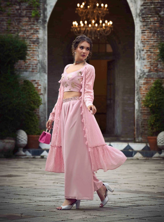 The model in the image is wearing Dusty Pink Classy Indo Western With Stylish Koti from Alice Milan. Crafted with the finest materials and impeccable attention to detail, the  looks premium, trendy, luxurious and offers unparalleled comfort. It’s a perfect clothing option for loungewear, resort wear, party wear or for an airport look. The woman in the image looks happy, and confident with her style statement putting a happy smile on her face.