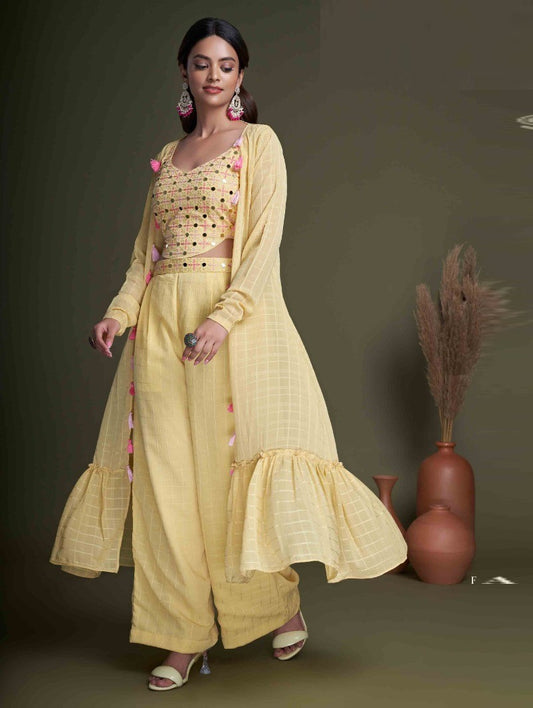 The model in the image is wearing Yellow Classy Indo Western With Stylish Koti from Alice Milan. Crafted with the finest materials and impeccable attention to detail, the  looks premium, trendy, luxurious and offers unparalleled comfort. It’s a perfect clothing option for loungewear, resort wear, party wear or for an airport look. The woman in the image looks happy, and confident with her style statement putting a happy smile on her face.