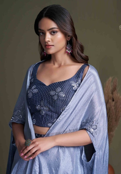 The model in the image is wearing Navy Blue Classy Indo Western With Stylish Koti from Alice Milan. Crafted with the finest materials and impeccable attention to detail, the  looks premium, trendy, luxurious and offers unparalleled comfort. It’s a perfect clothing option for loungewear, resort wear, party wear or for an airport look. The woman in the image looks happy, and confident with her style statement putting a happy smile on her face.
