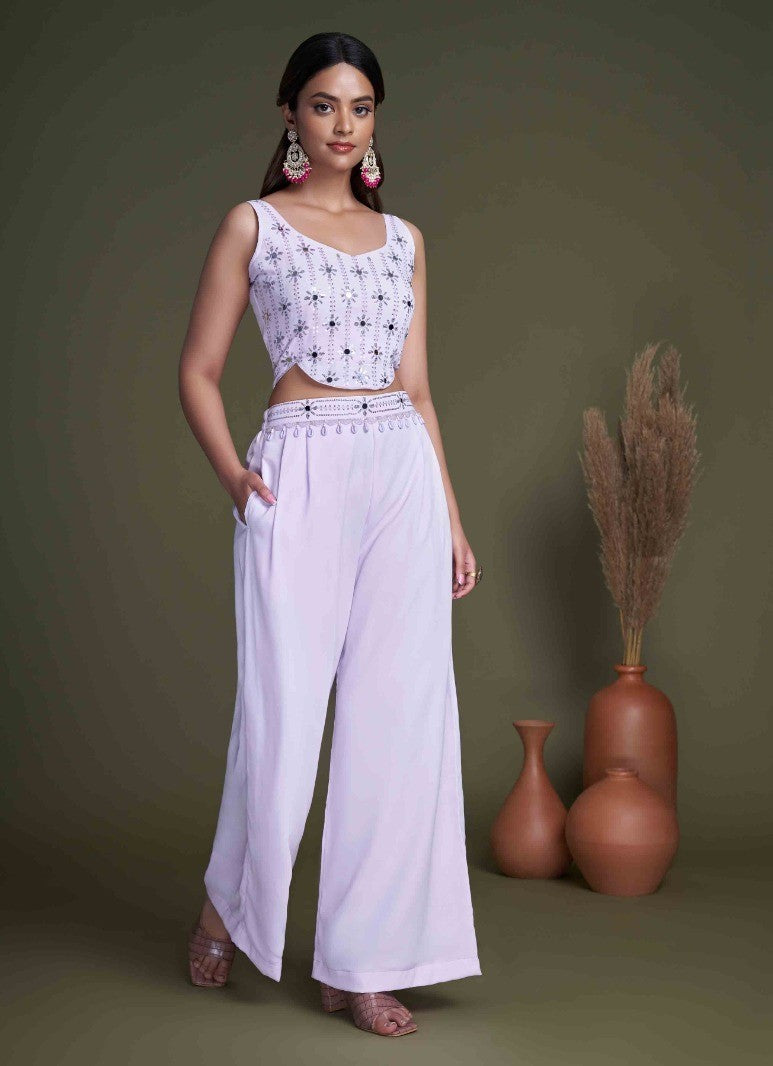 The model in the image is wearing Pastel Purple Classy Indo Western With Stylish Koti from Alice Milan. Crafted with the finest materials and impeccable attention to detail, the  looks premium, trendy, luxurious and offers unparalleled comfort. It’s a perfect clothing option for loungewear, resort wear, party wear or for an airport look. The woman in the image looks happy, and confident with her style statement putting a happy smile on her face.