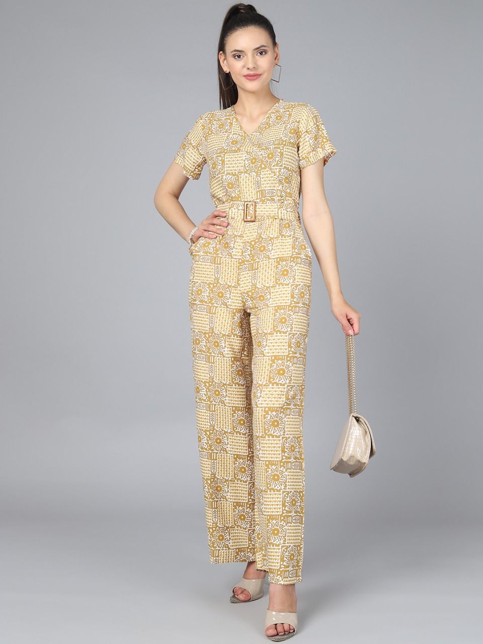 The model in the image is wearing Stylish Printed Women Jumpsuit - Yellow from Alice Milan. Crafted with the finest materials and impeccable attention to detail, the Jumpsuit looks premium, trendy, luxurious and offers unparalleled comfort. It’s a perfect clothing option for loungewear, resort wear, party wear or for an airport look. The woman in the image looks happy, and confident with her style statement putting a happy smile on her face.