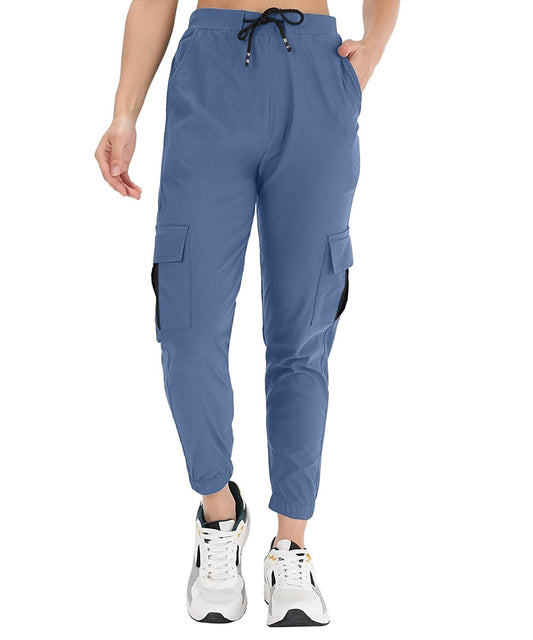The model in the image is wearing Prussian Blue Double Pocket Corgo Pant from Alice Milan. Crafted with the finest materials and impeccable attention to detail, the Cargo Pant looks premium, trendy, luxurious and offers unparalleled comfort. It’s a perfect clothing option for loungewear, resort wear, party wear or for an airport look. The woman in the image looks happy, and confident with her style statement putting a happy smile on her face.