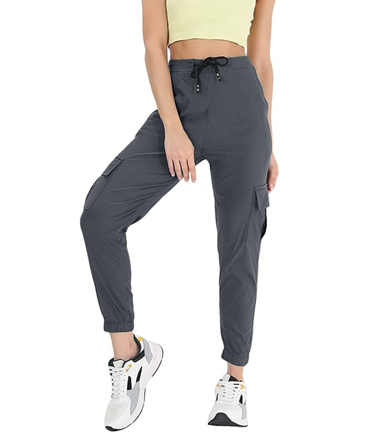The model in the image is wearing Dark Grey Double Pocket Corgo Pant from Alice Milan. Crafted with the finest materials and impeccable attention to detail, the Cargo Pant looks premium, trendy, luxurious and offers unparalleled comfort. It’s a perfect clothing option for loungewear, resort wear, party wear or for an airport look. The woman in the image looks happy, and confident with her style statement putting a happy smile on her face.