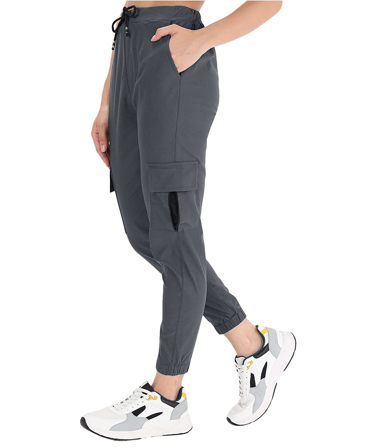 The model in the image is wearing Dark Grey Double Pocket Corgo Pant from Alice Milan. Crafted with the finest materials and impeccable attention to detail, the Cargo Pant looks premium, trendy, luxurious and offers unparalleled comfort. It’s a perfect clothing option for loungewear, resort wear, party wear or for an airport look. The woman in the image looks happy, and confident with her style statement putting a happy smile on her face.