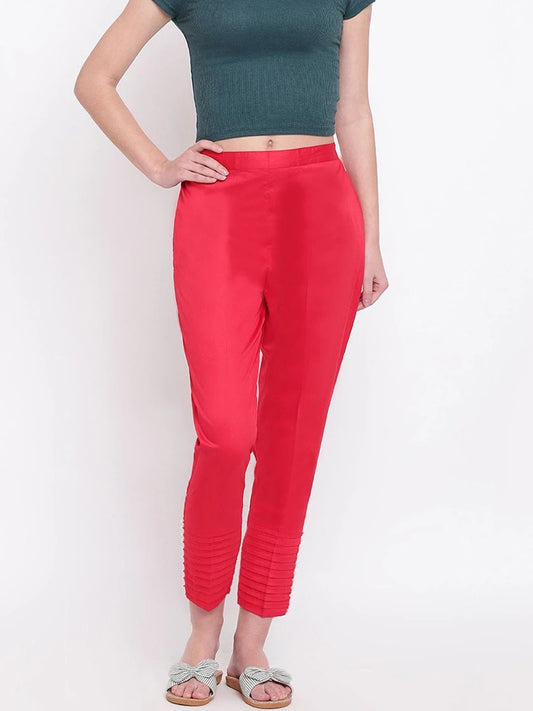 The model in the image is wearing Red Pintex Silk Women's Pant from Alice Milan. Crafted with the finest materials and impeccable attention to detail, the Women's Pant looks premium, trendy, luxurious and offers unparalleled comfort. It’s a perfect clothing option for loungewear, resort wear, party wear or for an airport look. The woman in the image looks happy, and confident with her style statement putting a happy smile on her face.