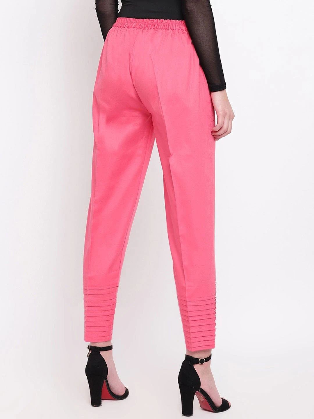 The model in the image is wearing Light Pink Pintex Silk Women's Pant from Alice Milan. Crafted with the finest materials and impeccable attention to detail, the Women's Pant looks premium, trendy, luxurious and offers unparalleled comfort. It’s a perfect clothing option for loungewear, resort wear, party wear or for an airport look. The woman in the image looks happy, and confident with her style statement putting a happy smile on her face.
