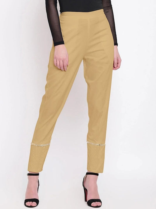 The model in the image is wearing Beige Pant For Women from Alice Milan. Crafted with the finest materials and impeccable attention to detail, the Women's Pant looks premium, trendy, luxurious and offers unparalleled comfort. It’s a perfect clothing option for loungewear, resort wear, party wear or for an airport look. The woman in the image looks happy, and confident with her style statement putting a happy smile on her face.