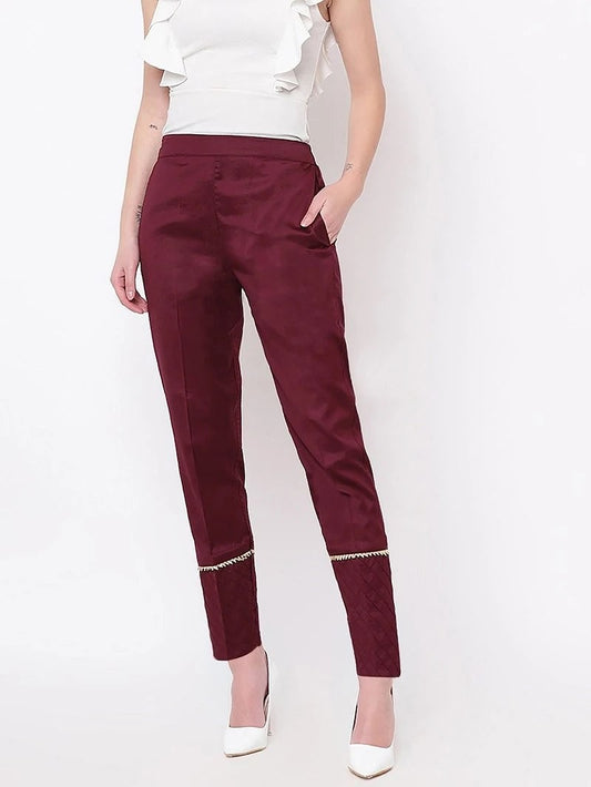 The model in the image is wearing Maroon Pant For Women from Alice Milan. Crafted with the finest materials and impeccable attention to detail, the Women's Pant looks premium, trendy, luxurious and offers unparalleled comfort. It’s a perfect clothing option for loungewear, resort wear, party wear or for an airport look. The woman in the image looks happy, and confident with her style statement putting a happy smile on her face.