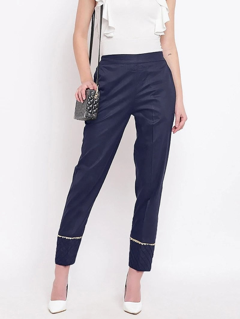 The model in the image is wearing Navy Blue Pant For Women from Alice Milan. Crafted with the finest materials and impeccable attention to detail, the Women's Pant looks premium, trendy, luxurious and offers unparalleled comfort. It’s a perfect clothing option for loungewear, resort wear, party wear or for an airport look. The woman in the image looks happy, and confident with her style statement putting a happy smile on her face.