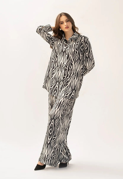 The model in the image is wearing Safari Slumber Animal Printed Co ord Set from Alice Milan. Crafted with the finest materials and impeccable attention to detail, the Co-ord Set looks premium, trendy, luxurious and offers unparalleled comfort. It’s a perfect clothing option for loungewear, resort wear, party wear or for an airport look. The woman in the image looks happy, and confident with her style statement putting a happy smile on her face.