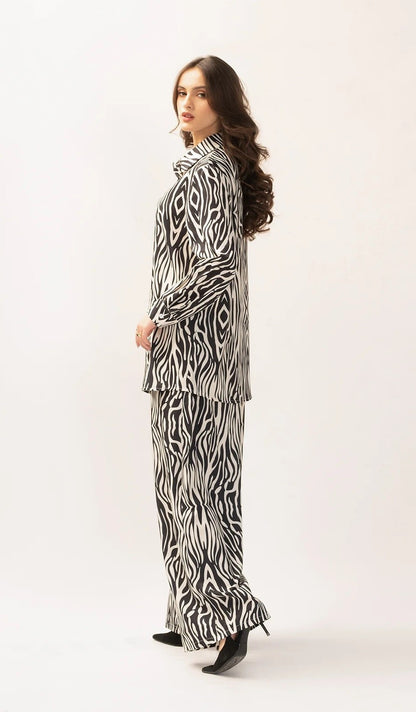 The model in the image is wearing Safari Slumber Animal Printed Co ord Set from Alice Milan. Crafted with the finest materials and impeccable attention to detail, the Co-ord Set looks premium, trendy, luxurious and offers unparalleled comfort. It’s a perfect clothing option for loungewear, resort wear, party wear or for an airport look. The woman in the image looks happy, and confident with her style statement putting a happy smile on her face.