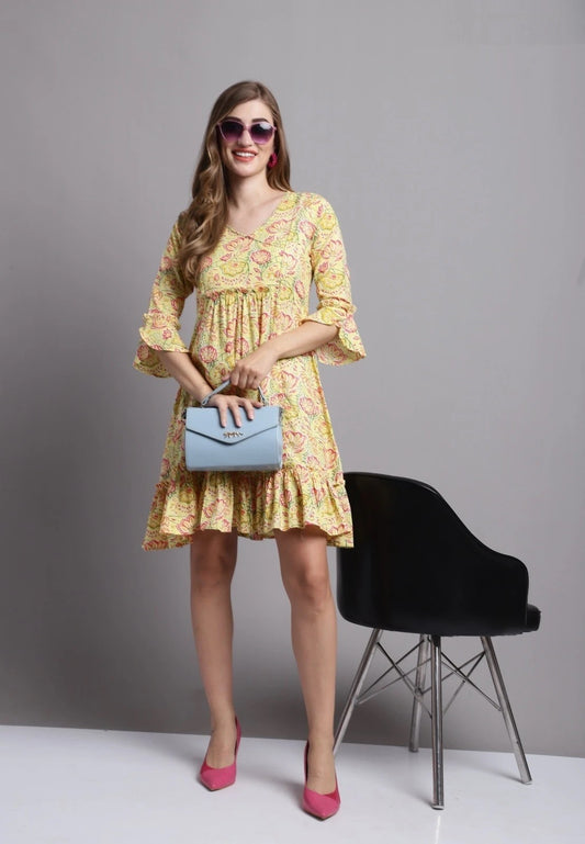 The model in the image is wearing Yellow Casual Tunic Top With Bell Sleeves from Alice Milan. Crafted with the finest materials and impeccable attention to detail, the Tunic Top looks premium, trendy, luxurious and offers unparalleled comfort. It’s a perfect clothing option for loungewear, resort wear, party wear or for an airport look. The woman in the image looks happy, and confident with her style statement putting a happy smile on her face.