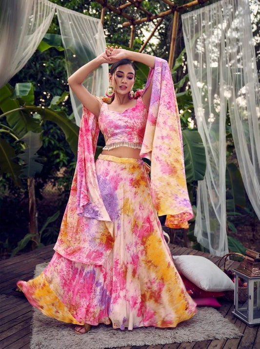 The model in the image is wearing Purple Pink Tie & Dye Silk Fancy Shoulder Dupatta Style Indo Western from Alice Milan. Crafted with the finest materials and impeccable attention to detail, the  looks premium, trendy, luxurious and offers unparalleled comfort. It’s a perfect clothing option for loungewear, resort wear, party wear or for an airport look. The woman in the image looks happy, and confident with her style statement putting a happy smile on her face.