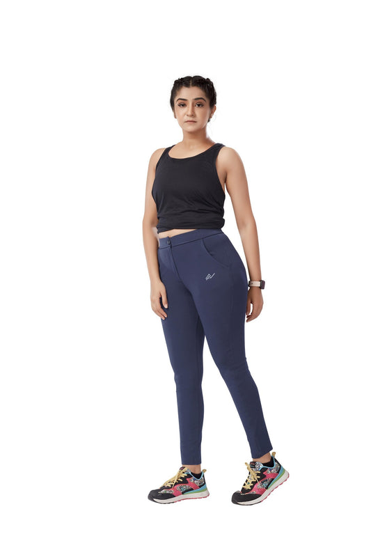 The model in the image is wearing Blue Colour Polyester Solid Pattern Track Pant For Women's from Alice Milan. Crafted with the finest materials and impeccable attention to detail, the Track Pant looks premium, trendy, luxurious and offers unparalleled comfort. It’s a perfect clothing option for loungewear, resort wear, party wear or for an airport look. The woman in the image looks happy, and confident with her style statement putting a happy smile on her face.