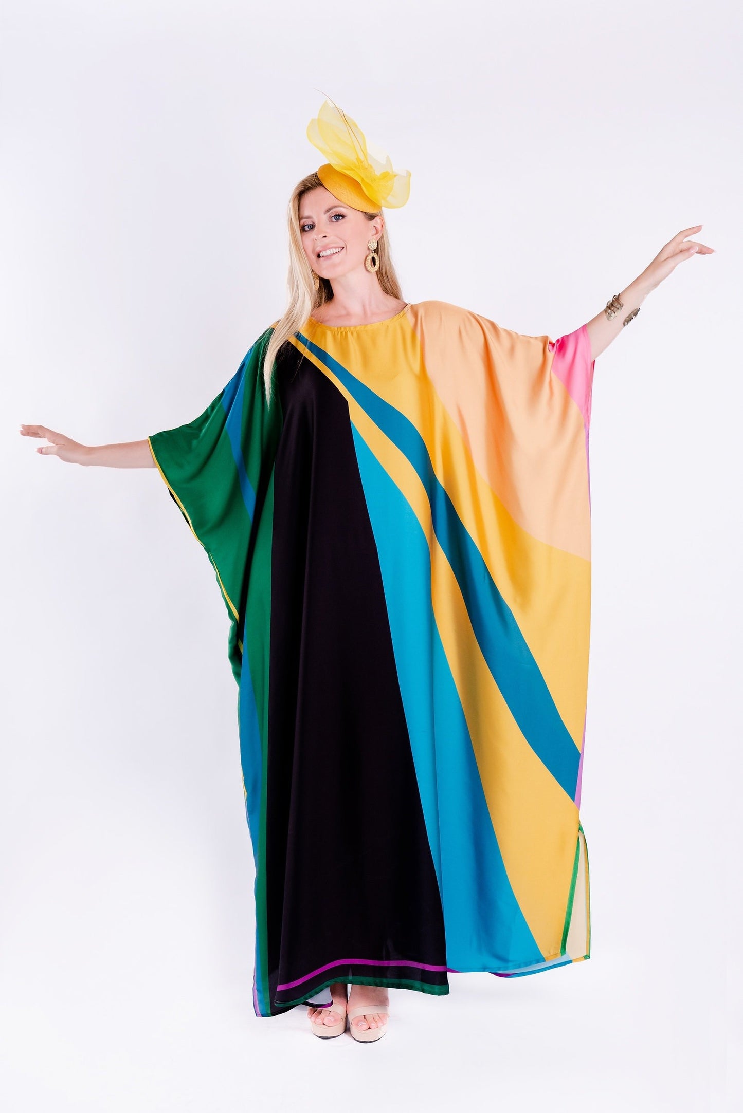 The model in the image is wearing Multicolor Printed Satin Silk Party Wear Kaftan from Alice Milan. Crafted with the finest materials and impeccable attention to detail, the Partywear Dress looks premium, trendy, luxurious and offers unparalleled comfort. It’s a perfect clothing option for loungewear, resort wear, party wear or for an airport look. The woman in the image looks happy, and confident with her style statement putting a happy smile on her face.