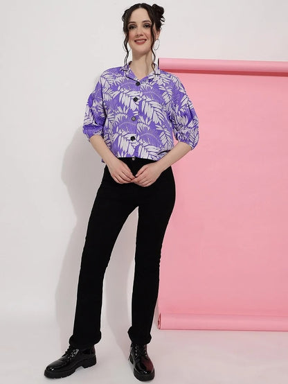 The model in the image is wearing Purple Colour Casual Wear Crepe Printed Shirt For Women from Alice Milan. Crafted with the finest materials and impeccable attention to detail, the Western Wear Top looks premium, trendy, luxurious and offers unparalleled comfort. It’s a perfect clothing option for loungewear, resort wear, party wear or for an airport look. The woman in the image looks happy, and confident with her style statement putting a happy smile on her face.