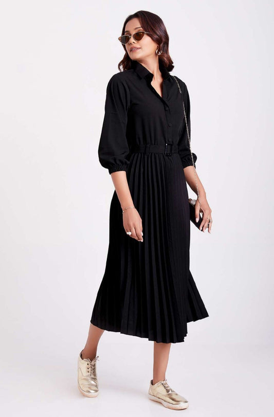 The model in the image is wearing Black Colour Pleated Western Wear Drees For Women from Alice Milan. Crafted with the finest materials and impeccable attention to detail, the Dress looks premium, trendy, luxurious and offers unparalleled comfort. It’s a perfect clothing option for loungewear, resort wear, party wear or for an airport look. The woman in the image looks happy, and confident with her style statement putting a happy smile on her face.