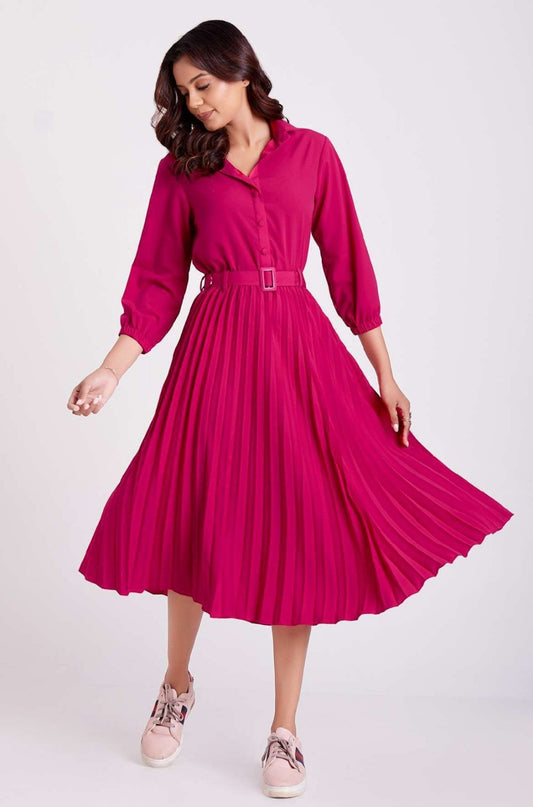 The model in the image is wearing Milano Pink Pleated Shirt Dress For Women from Alice Milan. Crafted with the finest materials and impeccable attention to detail, the Dress looks premium, trendy, luxurious and offers unparalleled comfort. It’s a perfect clothing option for loungewear, resort wear, party wear or for an airport look. The woman in the image looks happy, and confident with her style statement putting a happy smile on her face.