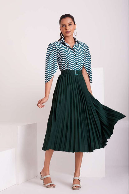 The model in the image is wearing Green and White Pleated Western Wear Stylish Dress For Women from Alice Milan. Crafted with the finest materials and impeccable attention to detail, the Dress looks premium, trendy, luxurious and offers unparalleled comfort. It’s a perfect clothing option for loungewear, resort wear, party wear or for an airport look. The woman in the image looks happy, and confident with her style statement putting a happy smile on her face.