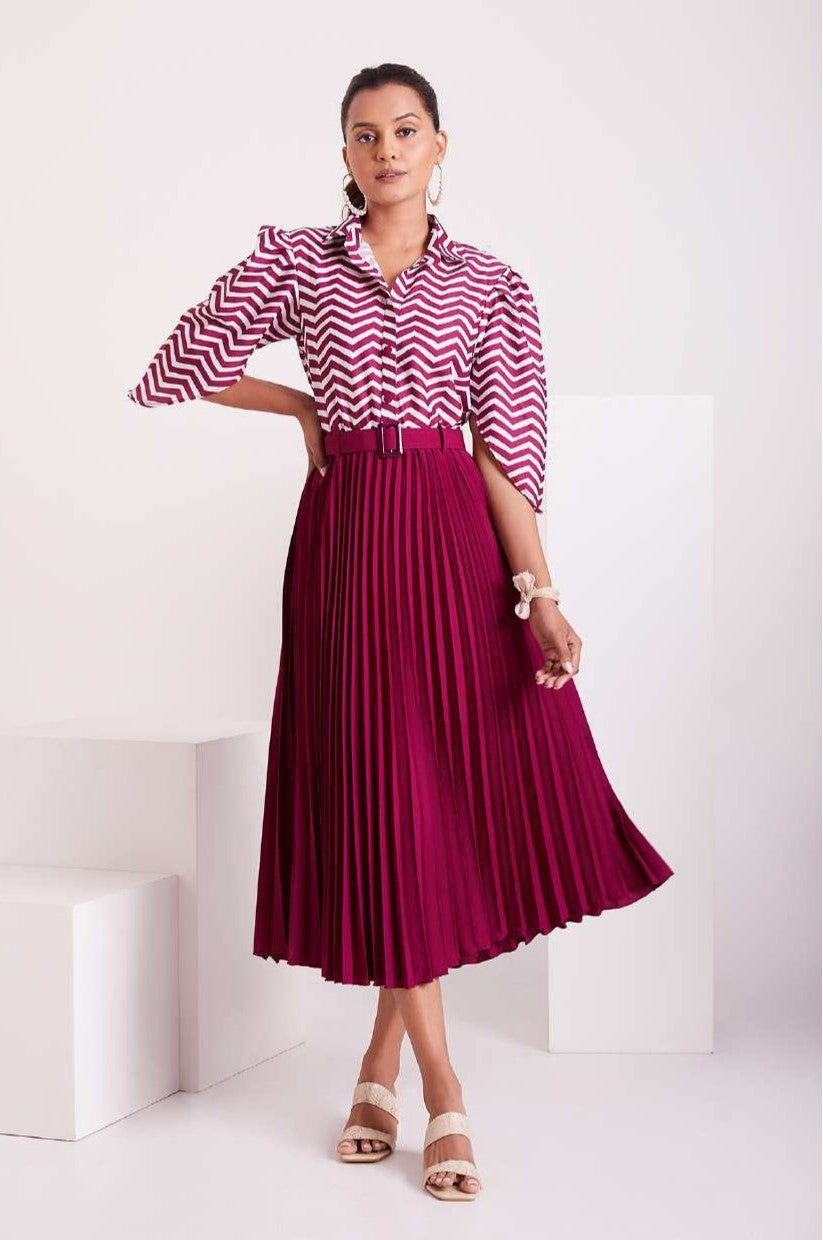 The model in the image is wearing Purple and White Pleated Western Wear Stylish Dress For Women from Alice Milan. Crafted with the finest materials and impeccable attention to detail, the Dress looks premium, trendy, luxurious and offers unparalleled comfort. It’s a perfect clothing option for loungewear, resort wear, party wear or for an airport look. The woman in the image looks happy, and confident with her style statement putting a happy smile on her face.