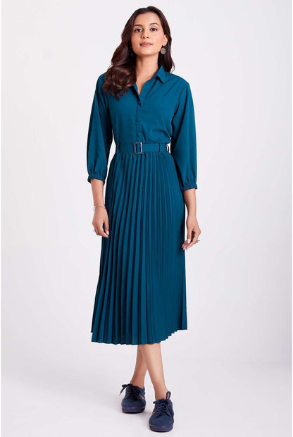 The model in the image is wearing Teal Blue Colour Pleated Western Wear Drees For Women from Alice Milan. Crafted with the finest materials and impeccable attention to detail, the Dress looks premium, trendy, luxurious and offers unparalleled comfort. It’s a perfect clothing option for loungewear, resort wear, party wear or for an airport look. The woman in the image looks happy, and confident with her style statement putting a happy smile on her face.