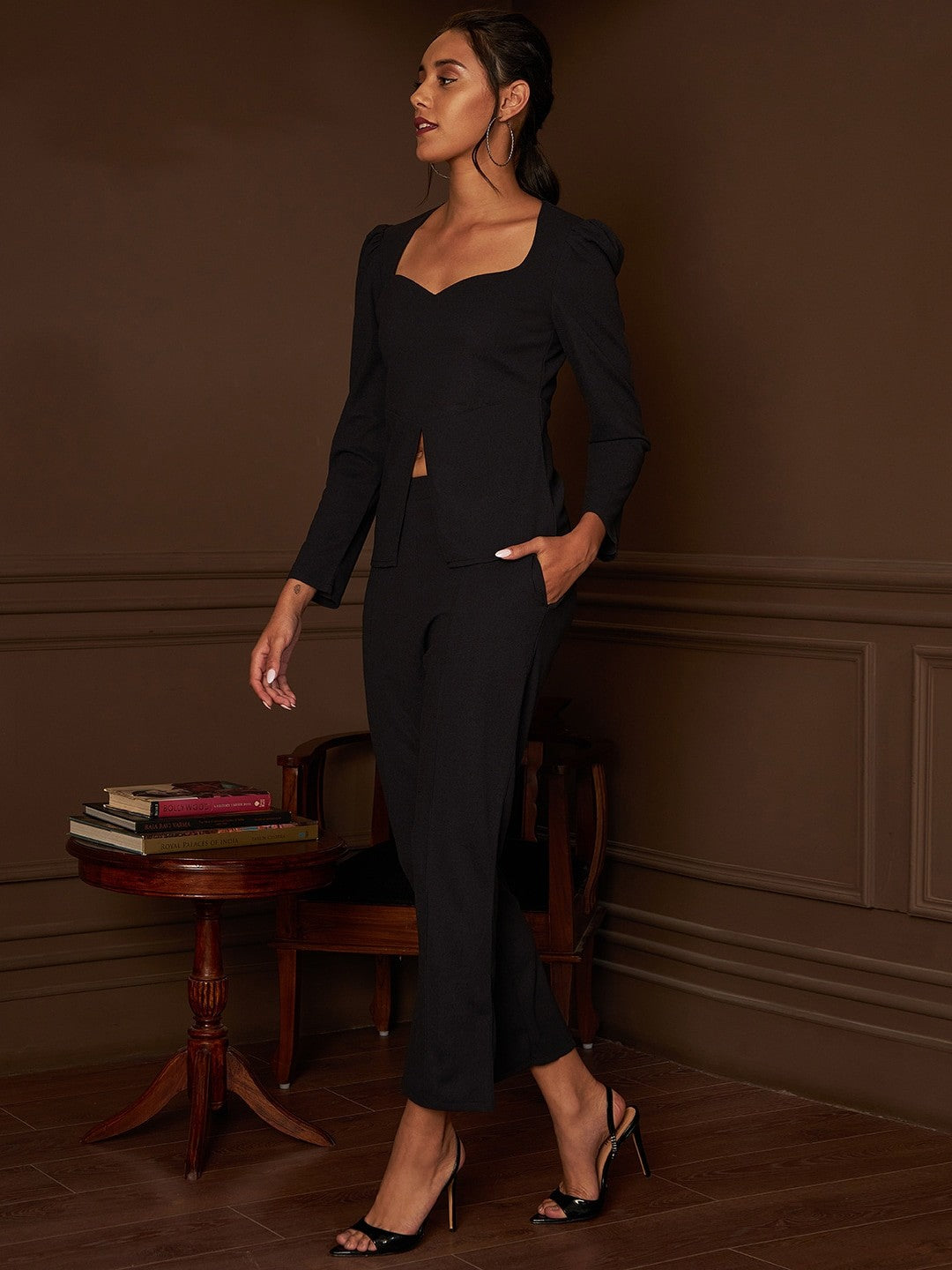 The model in the image is wearing BoldPower Black Co ord from Alice Milan. Crafted with the finest materials and impeccable attention to detail, the Formal Suit looks premium, trendy, luxurious and offers unparalleled comfort. It’s a perfect clothing option for loungewear, resort wear, party wear or for an airport look. The woman in the image looks happy, and confident with her style statement putting a happy smile on her face.
