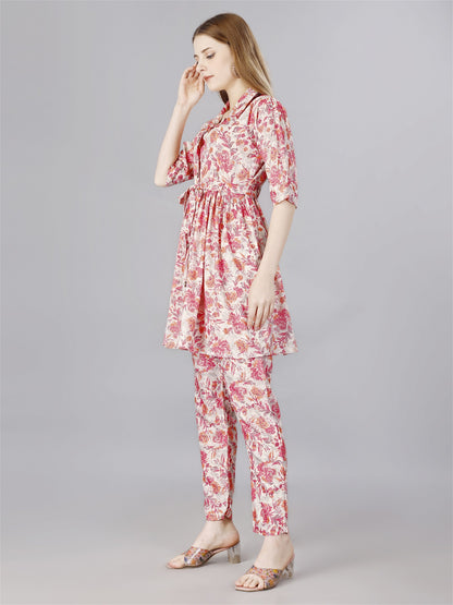 The model in the image is wearing Printed pink 2-Piece Shirt & Trousers Set from Alice Milan. Crafted with the finest materials and impeccable attention to detail, the  looks premium, trendy, luxurious and offers unparalleled comfort. It’s a perfect clothing option for loungewear, resort wear, party wear or for an airport look. The woman in the image looks happy, and confident with her style statement putting a happy smile on her face.